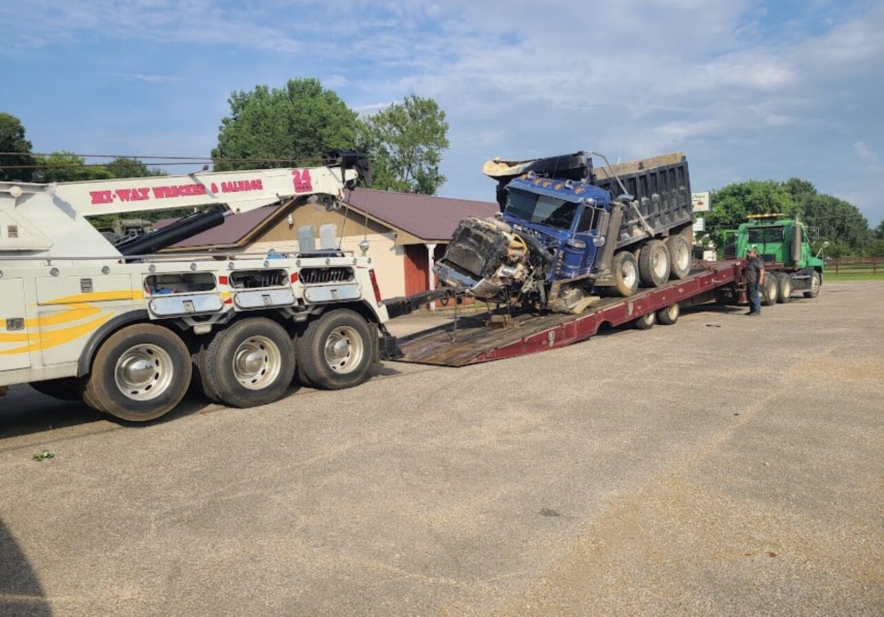 Wrecked dump truck loaded on lowboy trailer
