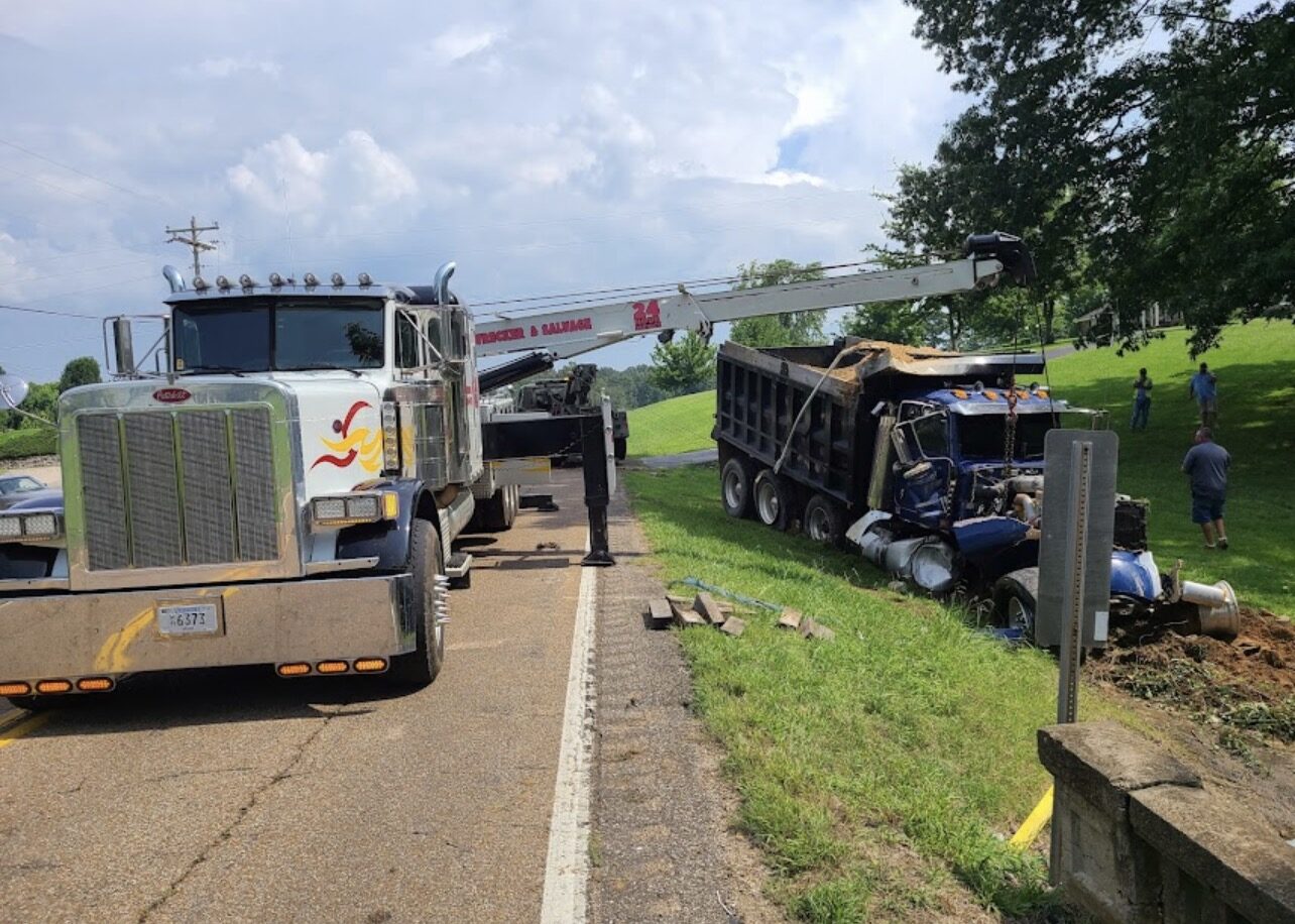 Heavy wrecker recovering a wrecked dump truck